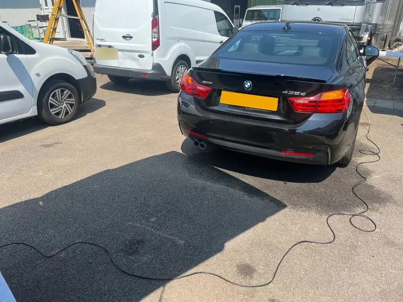 BMW 435d coupé connected to the van by a cable for its remap